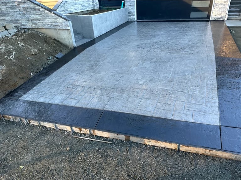 Newly installed patterned paver patio with geometric tile layout and wooden border edging