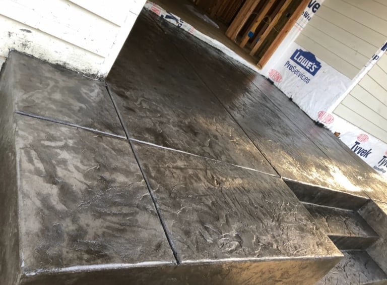 Weathered gray stone tiles laid on a floor next to wooden beams and white wall panels in an interior space